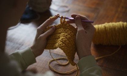 Pessoa fazendo crochê com barbante, demonstrando na prática os tipos de barbante para crochê em peça artesanal